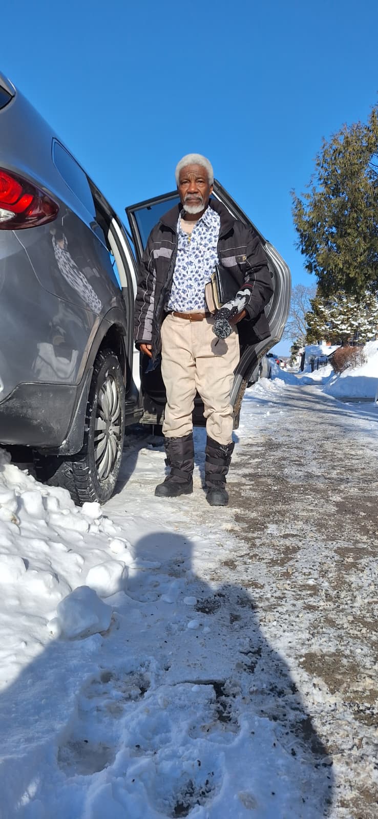 Pa Ndambi Paul Angemba near a car in the snow